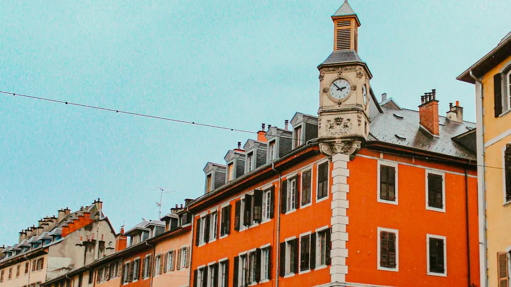 La place Saint-Léger à Chambéry, ses façades ocre et sa tour de l’horloge, après la pluie